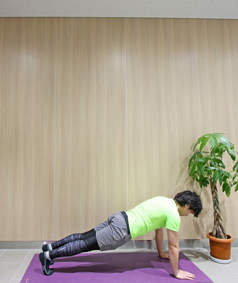 3.両手はつけたまま軽く飛び上がり、両足を後ろに伸ばして腕立て伏せの状態になります。