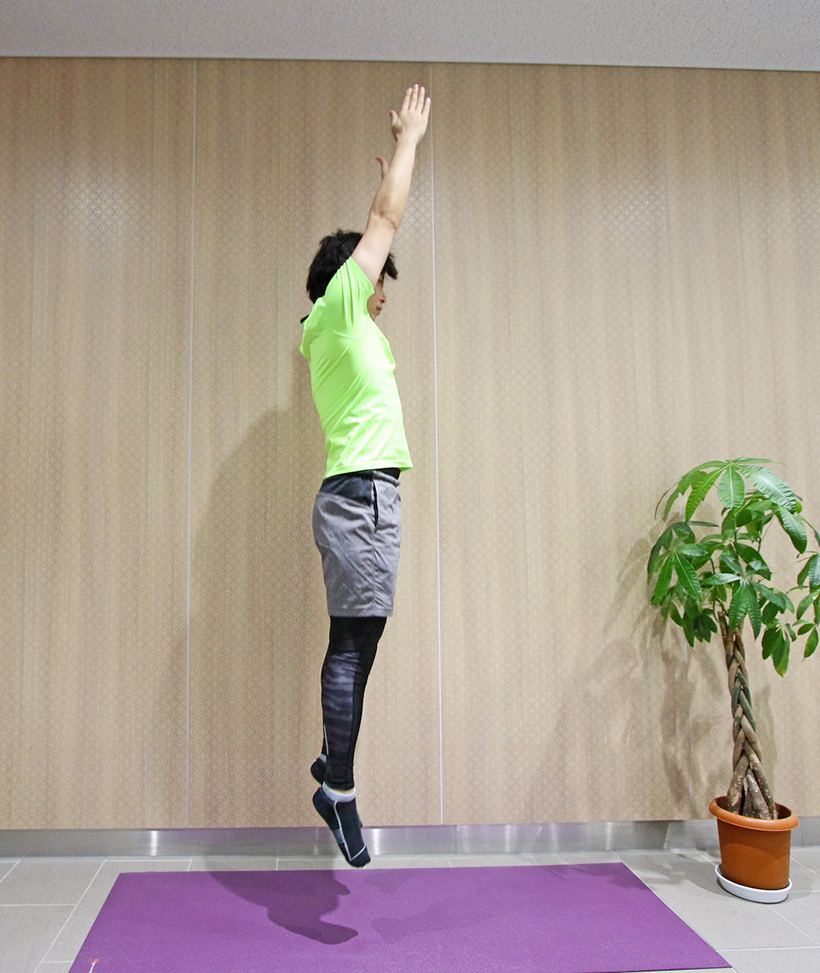 5.膝を伸ばしてその場で高くジャンプしましょう。このとき両手もまっすぐ上に伸ばします。